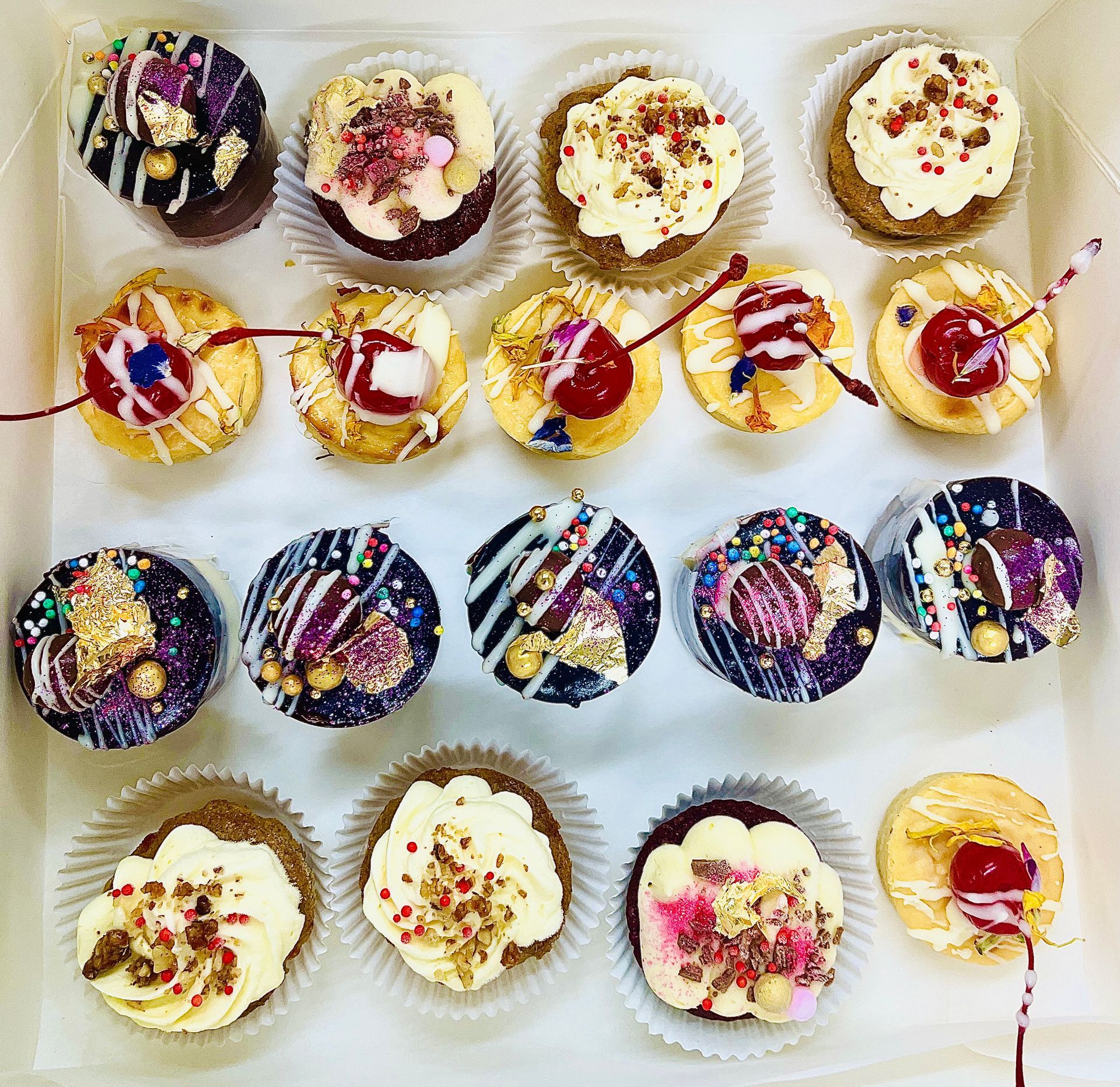 Box of mini cupcakes, various flavors, decorated with frosting, sprinkles, and cherries — My Rainbow Bakery, Cafe & Catering in Cannonvale, QLD