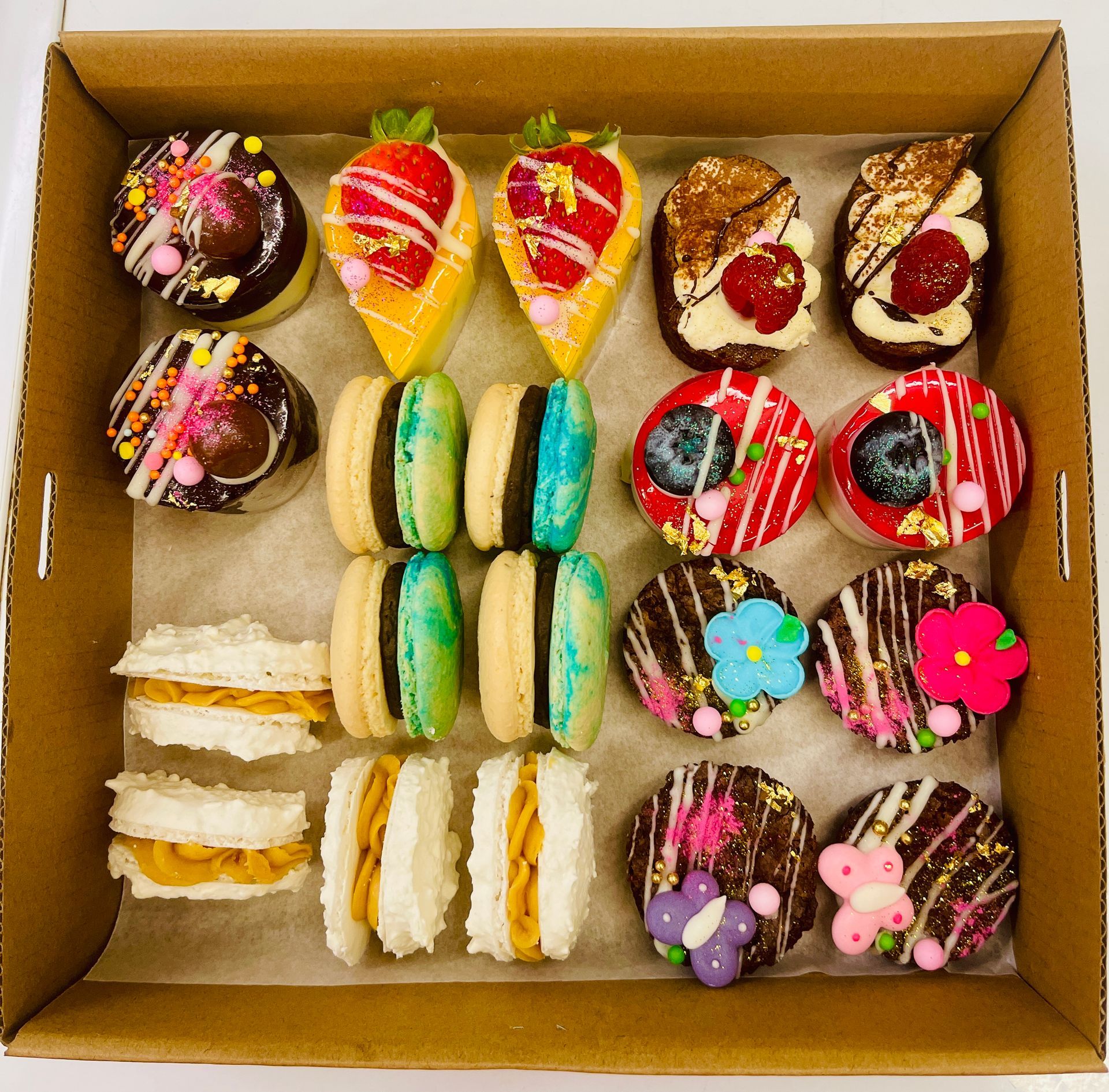 Box of colorful, decorated pastries including macarons, cakes, and cookies — My Rainbow Bakery, Cafe & Catering in Cannonvale, QLD