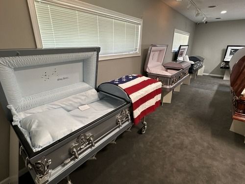 Open casket draped with American flag in a funeral home viewing room