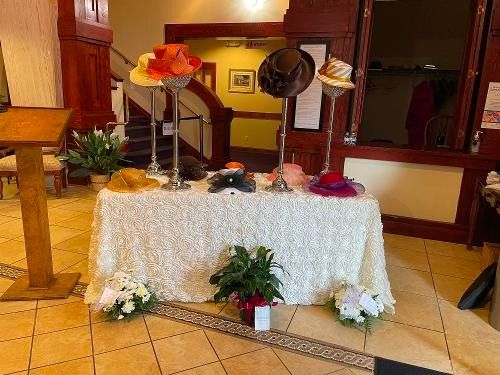 Decorated table with flowers and hats in a warm indoor lobby or hall