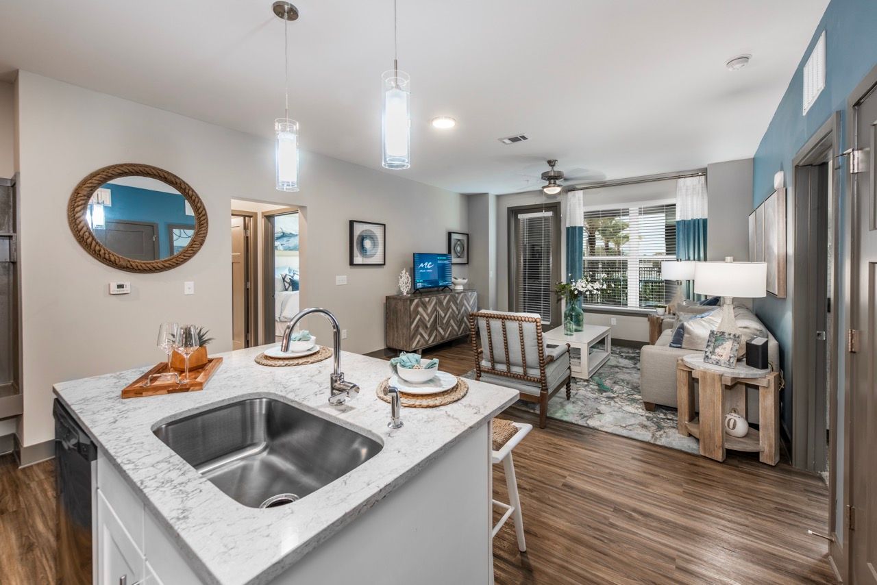 Open-concept living space with a kitchen island, seating area, and large window.