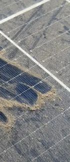Close-up of a cracked solar panel with dirt and weathering marks