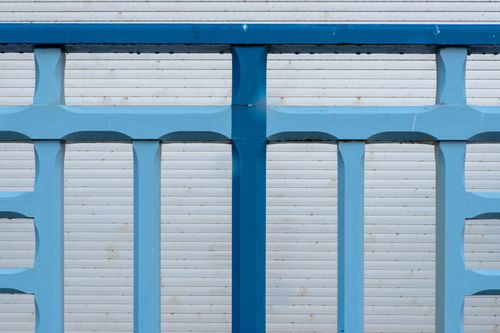 Blue metal barricade in front of a light gray garage door