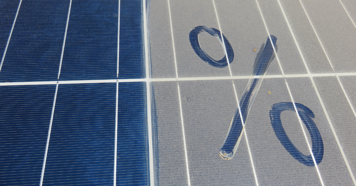 Solar panels with a white percent symbol overlaid, suggesting energy efficiency or discount