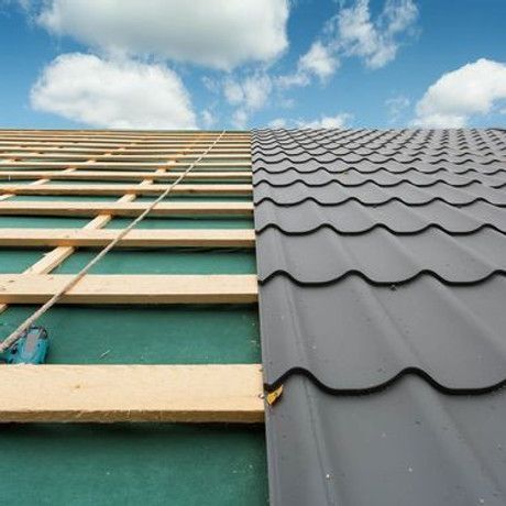 A roof is being built with wooden beams and a metal roof.