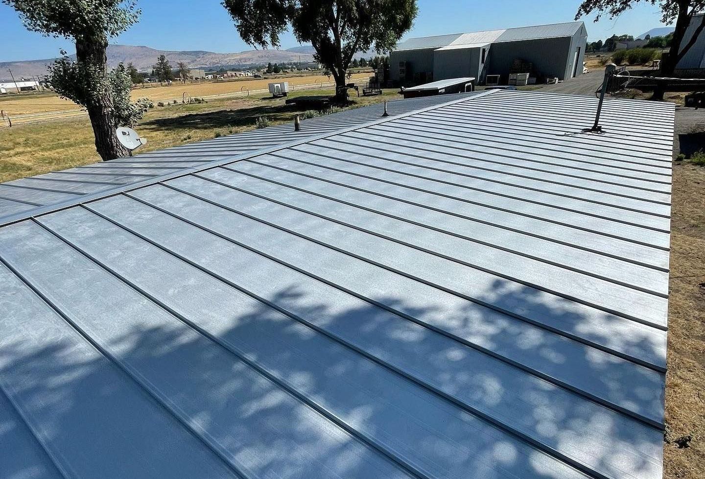 A roof with a lot of lines on it and trees in the background.
