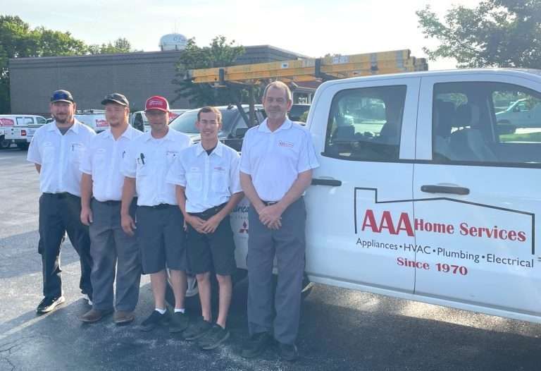 AAA Home Services crew standing beside a white service truck in a parking lot