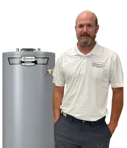 Man standing beside a gray water heater, wearing a white polo and dark pants, against a white background