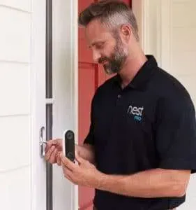 Man in black polo using a smart lock on a white front door