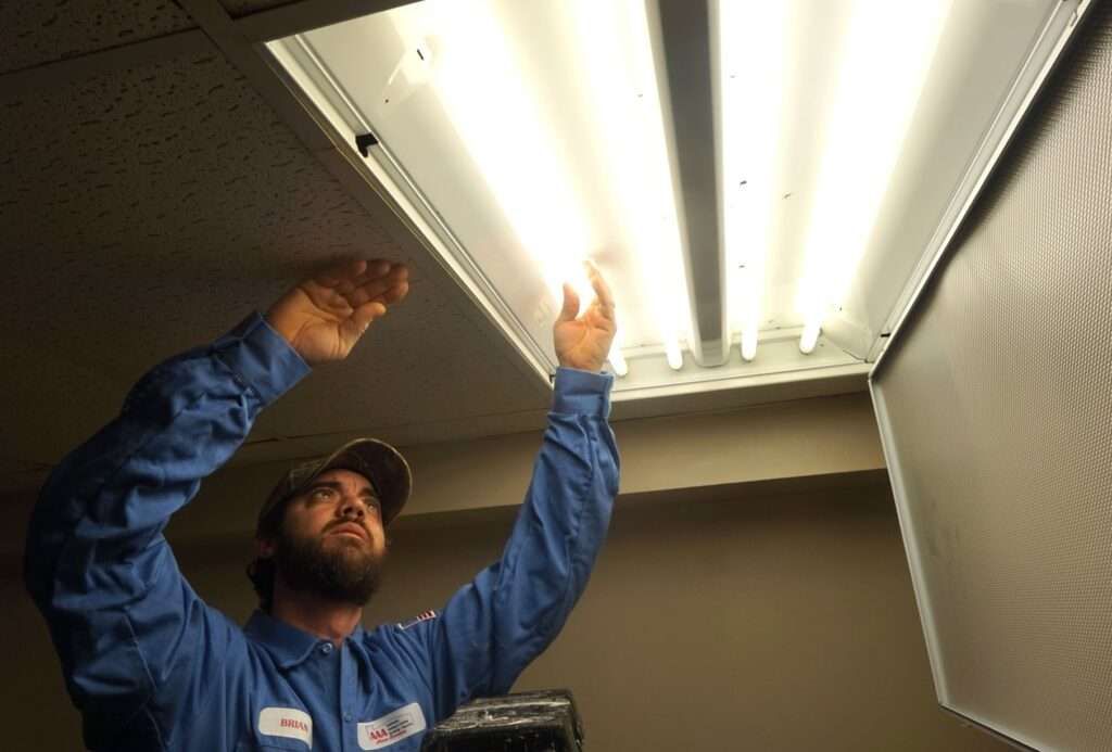 technician changing out a ceiling light