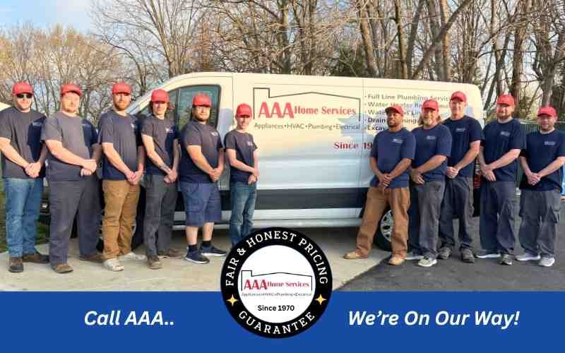 AAA roadside assistance crew posing beside a branded truck outdoors in winter.