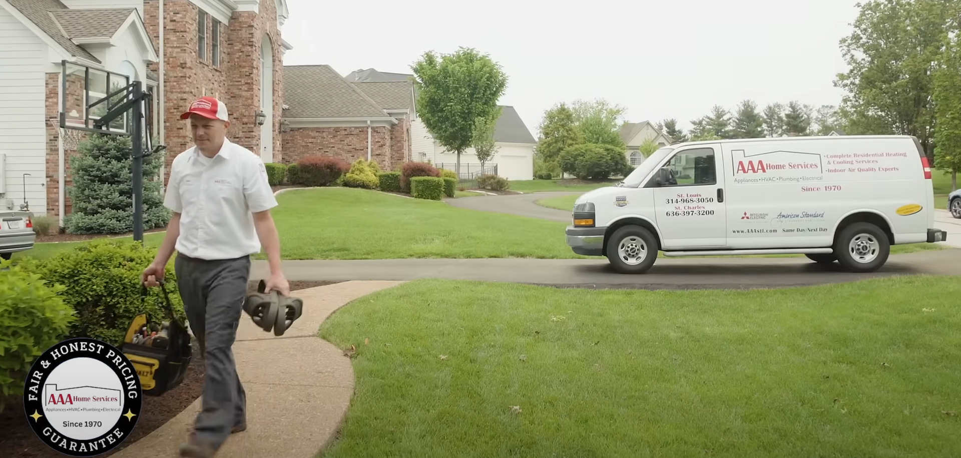 Man in red cap walking on a suburban sidewalk beside a white service van on a lawn