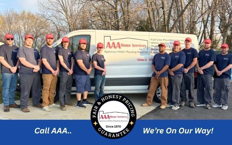 AAA Home Services team posing beside service vans with “Call AAA... We’re On Our Way!” branding