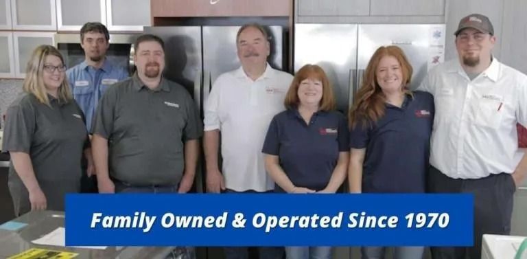Group of six employees standing in a business interior, with banner reading “Family Owned & Operated Since 1970”