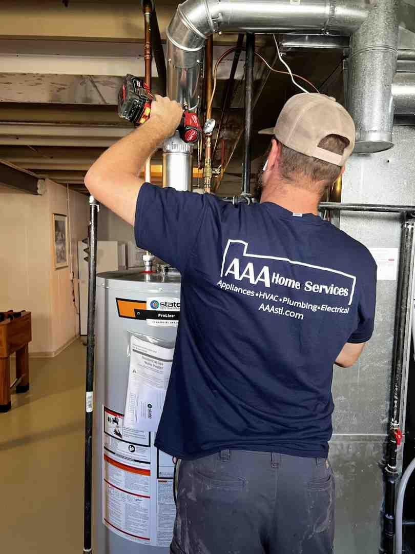 Technician in navy shirt adjusting pipes and equipment in a basement utility area