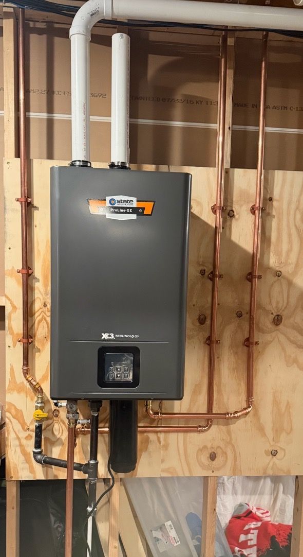 Wall-mounted electrical breaker panel in an unfinished basement with exposed copper piping.