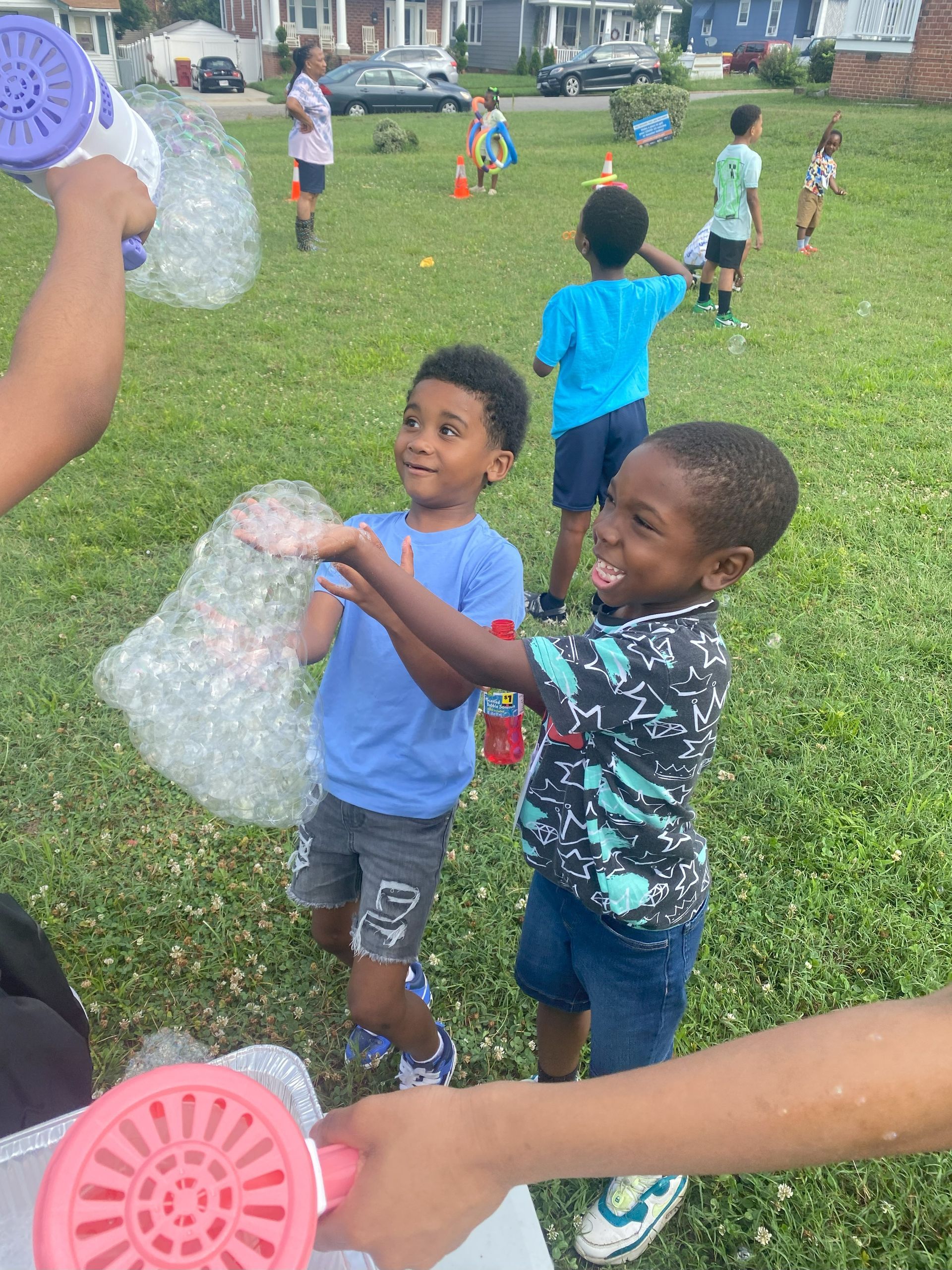 A group of children are playing with soap bubbles in a park.
