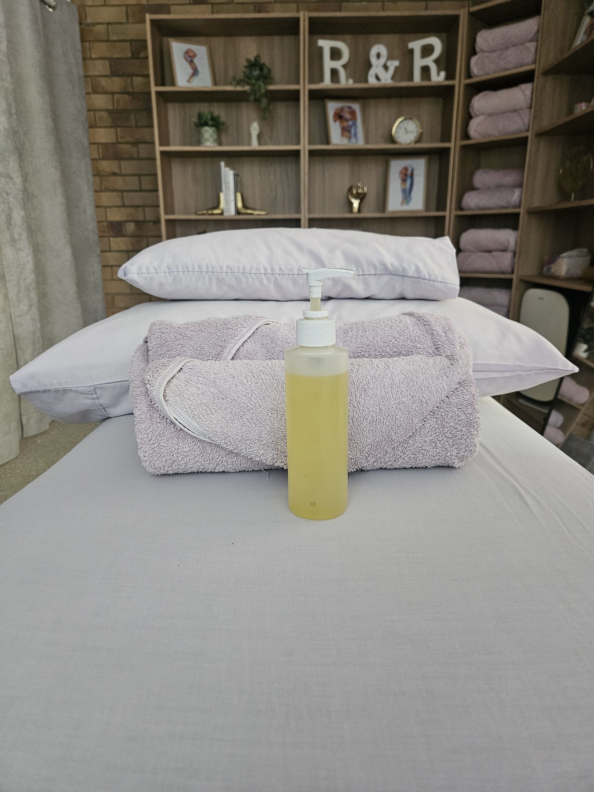 Massage Table with A Towel, Pillows, and Oil Bottle — R & R Relaxation and Remedial In Yamba, NSW