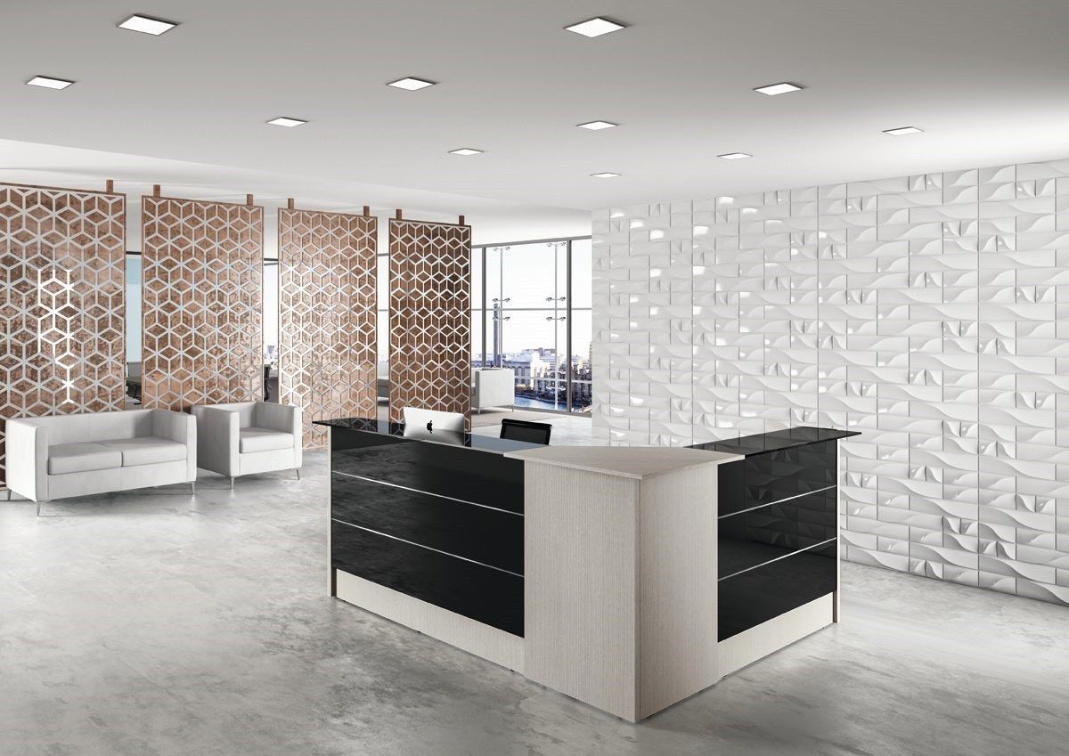 La reception di un ufficio moderno è caratterizzata da una scrivania a L in legno chiaro e nero, una parete bianca con finitura texturizzata e divisori decorativi.