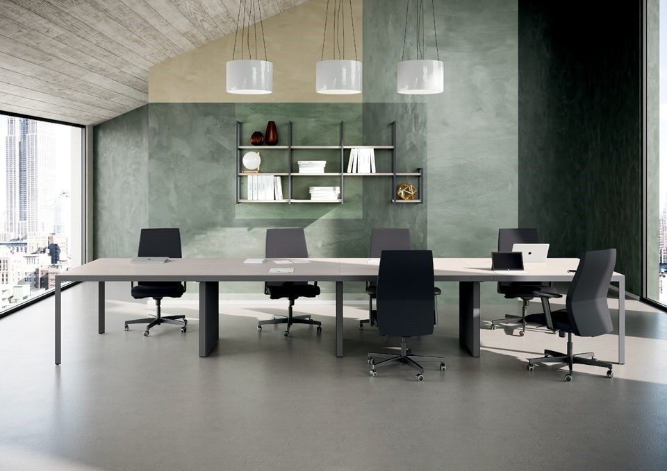 Una sala conferenze minimalista con un lungo tavolo bianco, sei sedie nere, mensole a muro e lampade a sospensione.