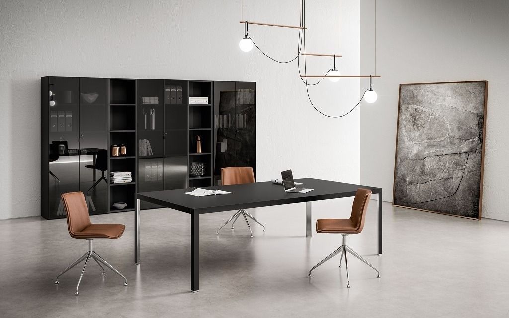 Un ufficio moderno presenta un tavolo scuro con sedie marroni, scaffali neri e lampade di design in una stanza.