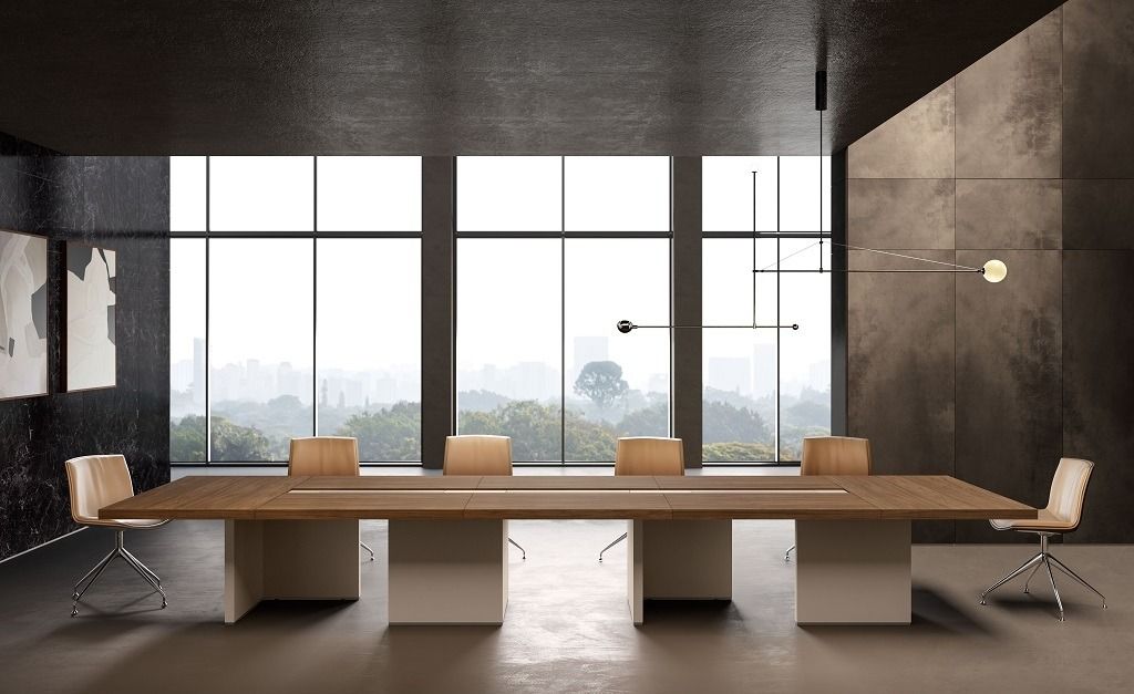Sala conferenze moderna con un grande tavolo in legno, sedie dai colori neutri e vetrate a tutta altezza con vista sulla città.