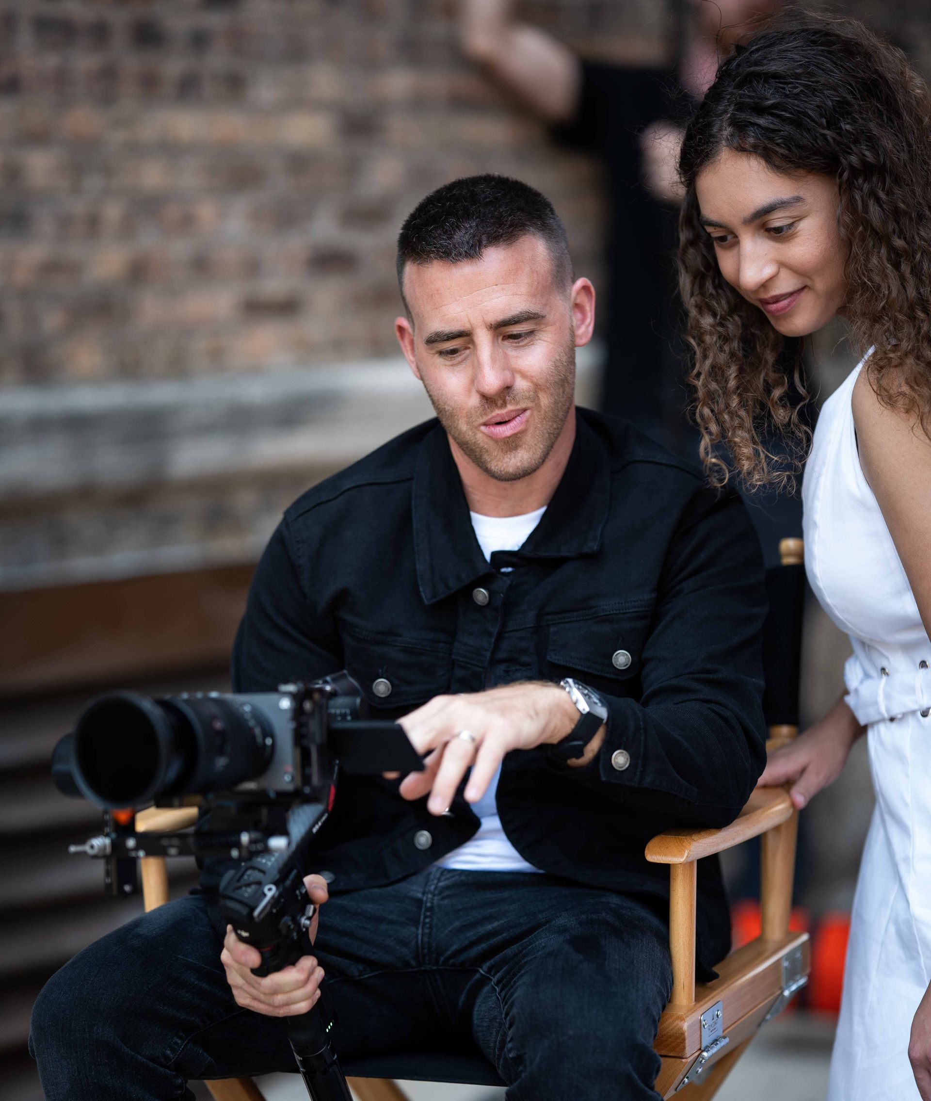 Alex Belville reviewing commercial video footage with a client during production.