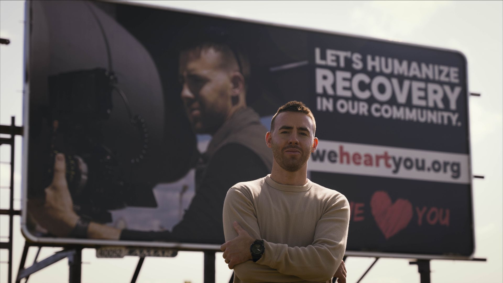 Mirrorless Productions filming a Wisconsin recovery awareness campaign in front of a Winnebago County community billboard for We Heart You.