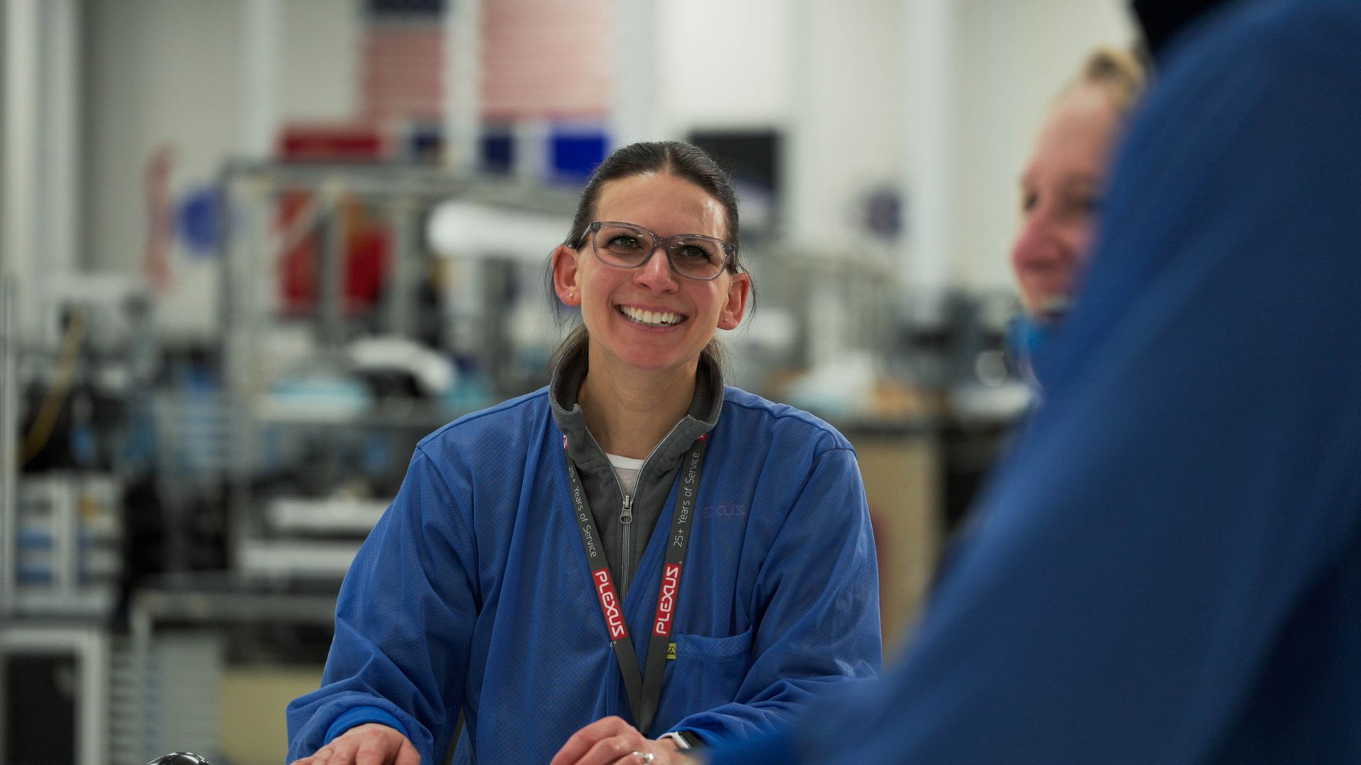 Plexus manufacturing team members collaborating inside a Wisconsin electronics manufacturing facility.