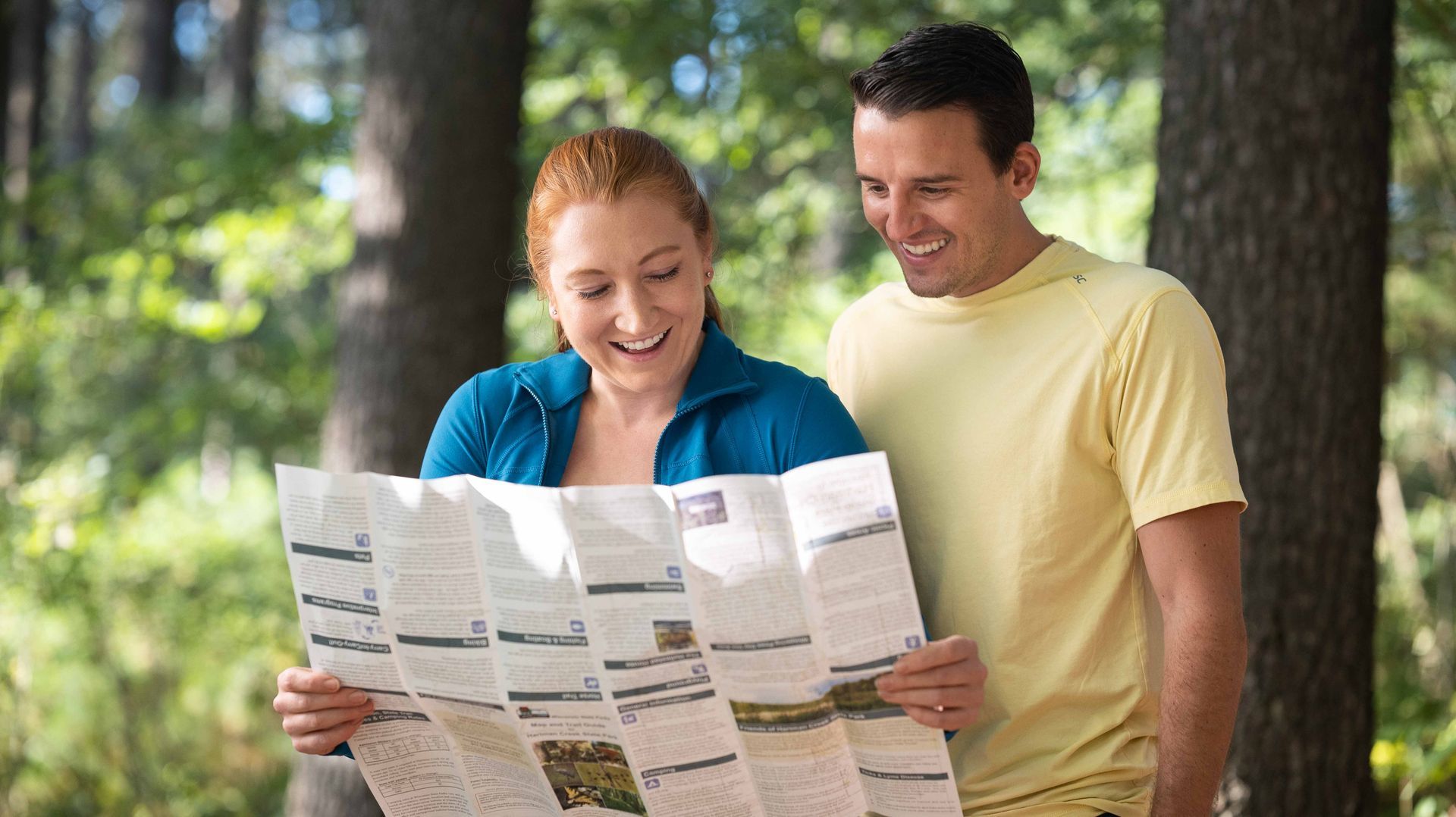 Wisconsin couple planning an outdoor adventure while viewing a trail map for a custom tourism website designed by Mirrorless Productions.