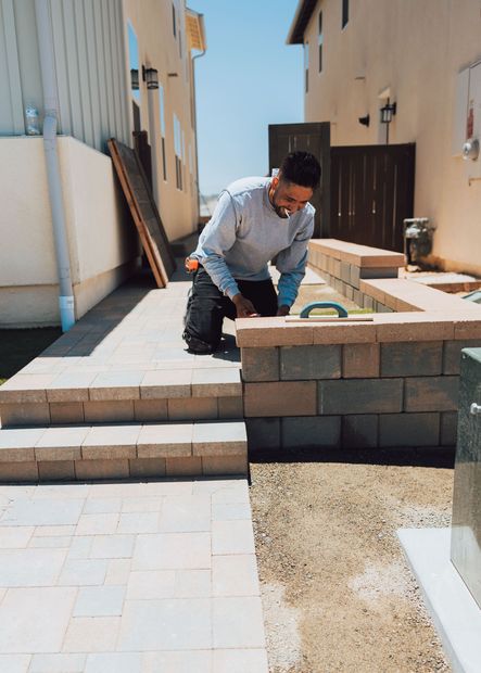 landscaping team installing pavers for patio project in San Diego