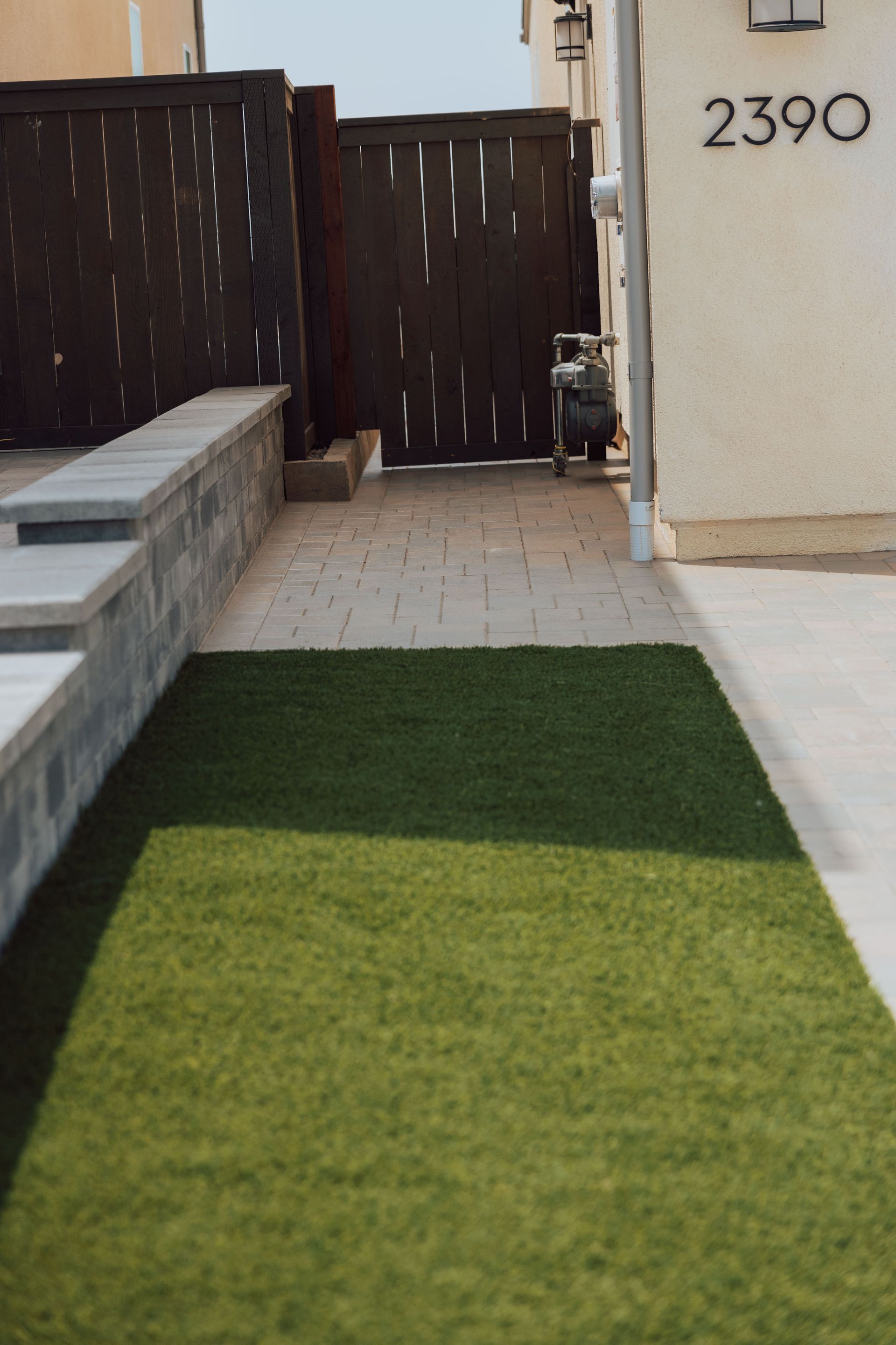 Artificial turf installation in a San Diego backyard creating a low maintenance green lawn with clean landscape design