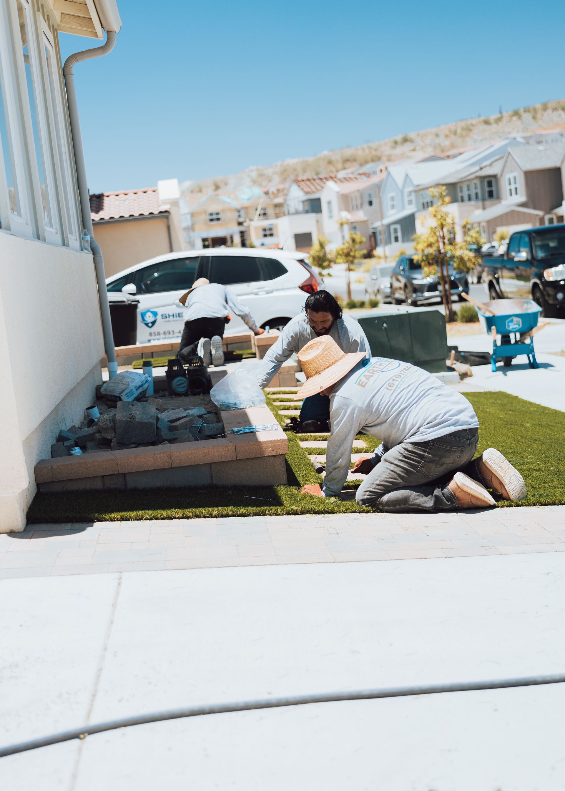 Experienced landscapers laying turf in a San Diego front yard