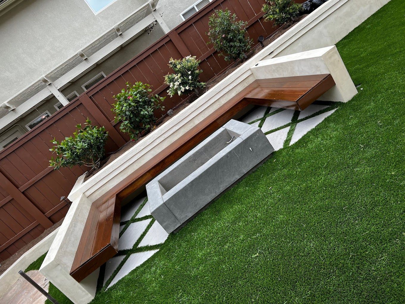 Custom concrete firepit with modern landscape design in a San Diego backyard