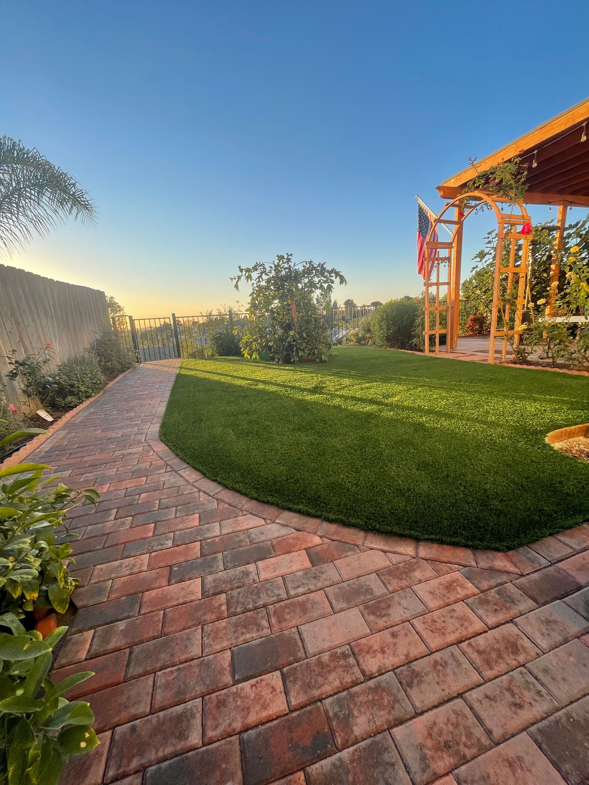 Full backyard landscape design in San Diego featuring turf, pavers, and decorative elements.