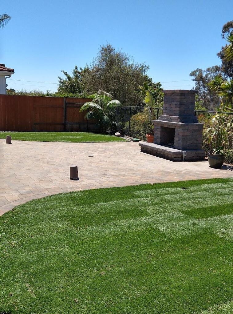 Backyard landscape design in San Diego featuring fire chimney and hardscape elements