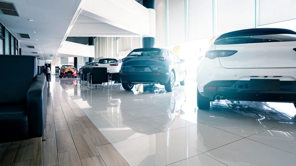Bright car showroom with sleek white and black vehicles on glossy floors