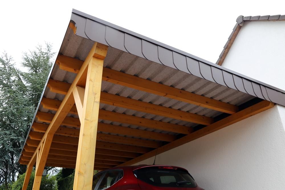 A Car Is Parked Under a Wooden Carport — Bundy Tiny Homes and Carports in Childers, QLD