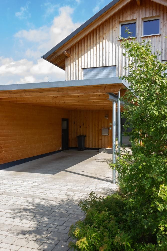 A Wooden House with A Carport and A Tree in Front of It — Bundy Tiny Homes and Carports in Bargara, QLD