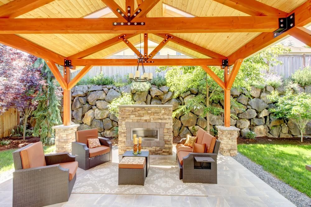 A Patio with Furniture and A Fireplace Under a Wooden Canopy — Bundy Tiny Homes and Carports in Bundaberg, QLD