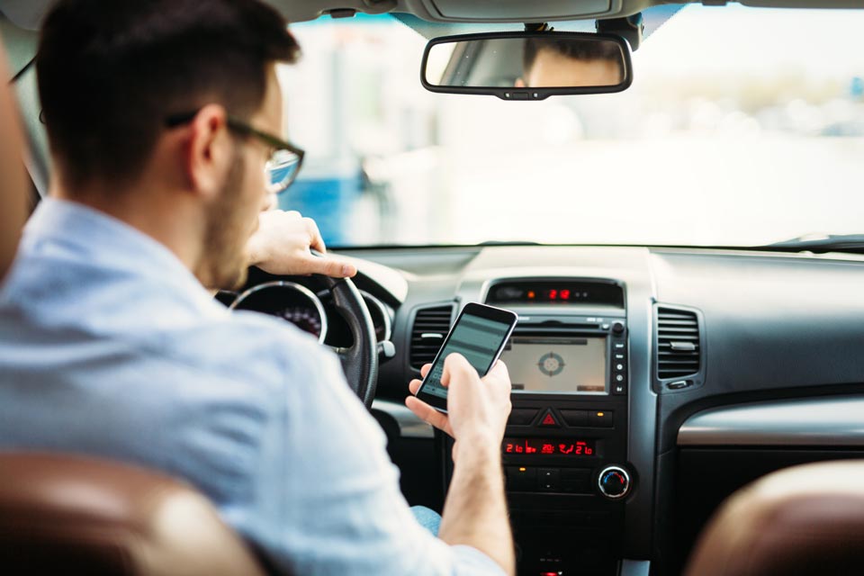 Kontrolle des Mobiltelefons während der Fahrt