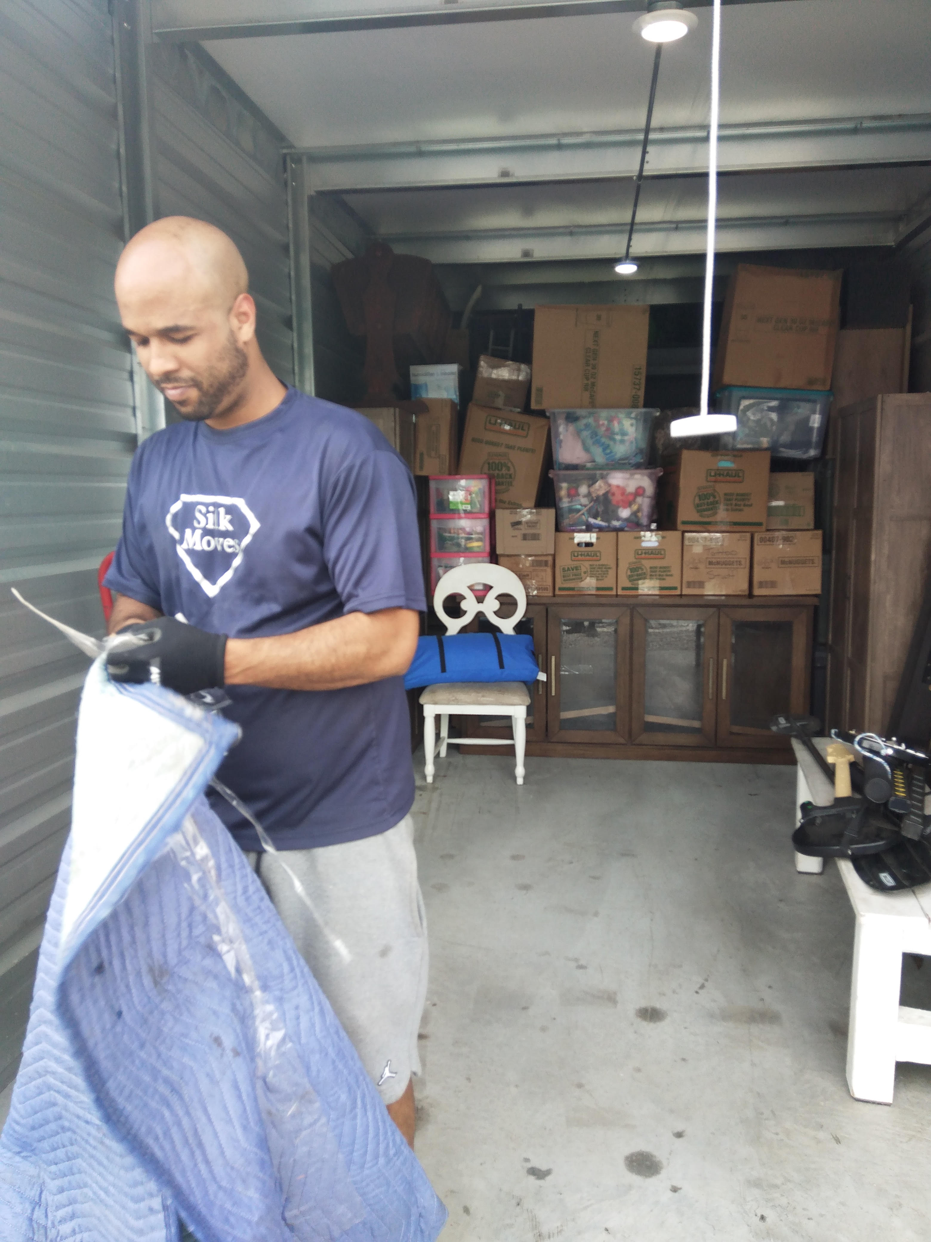 A man in a superman shirt is standing in a warehouse