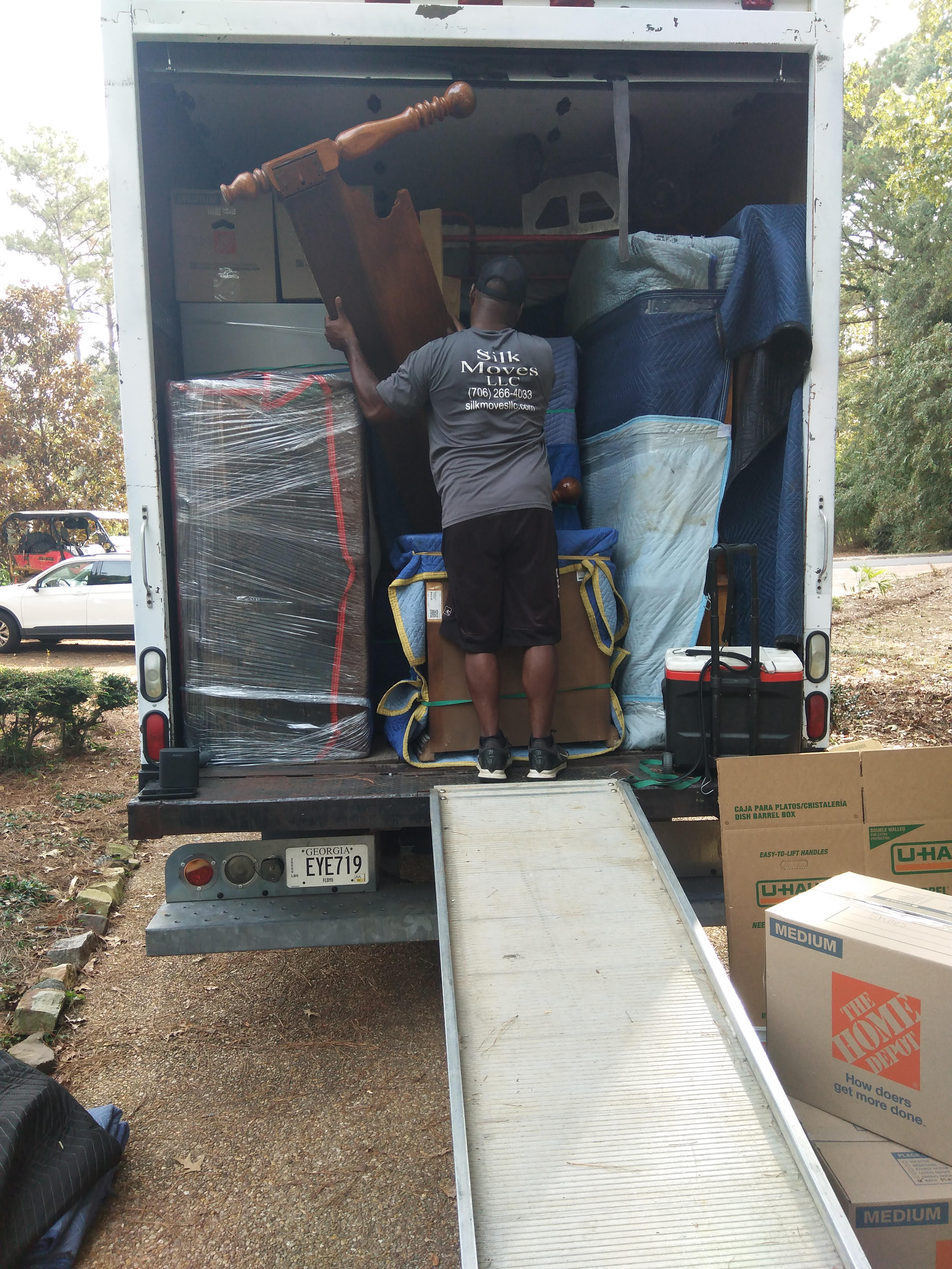 A man is standing in the back of a moving truck