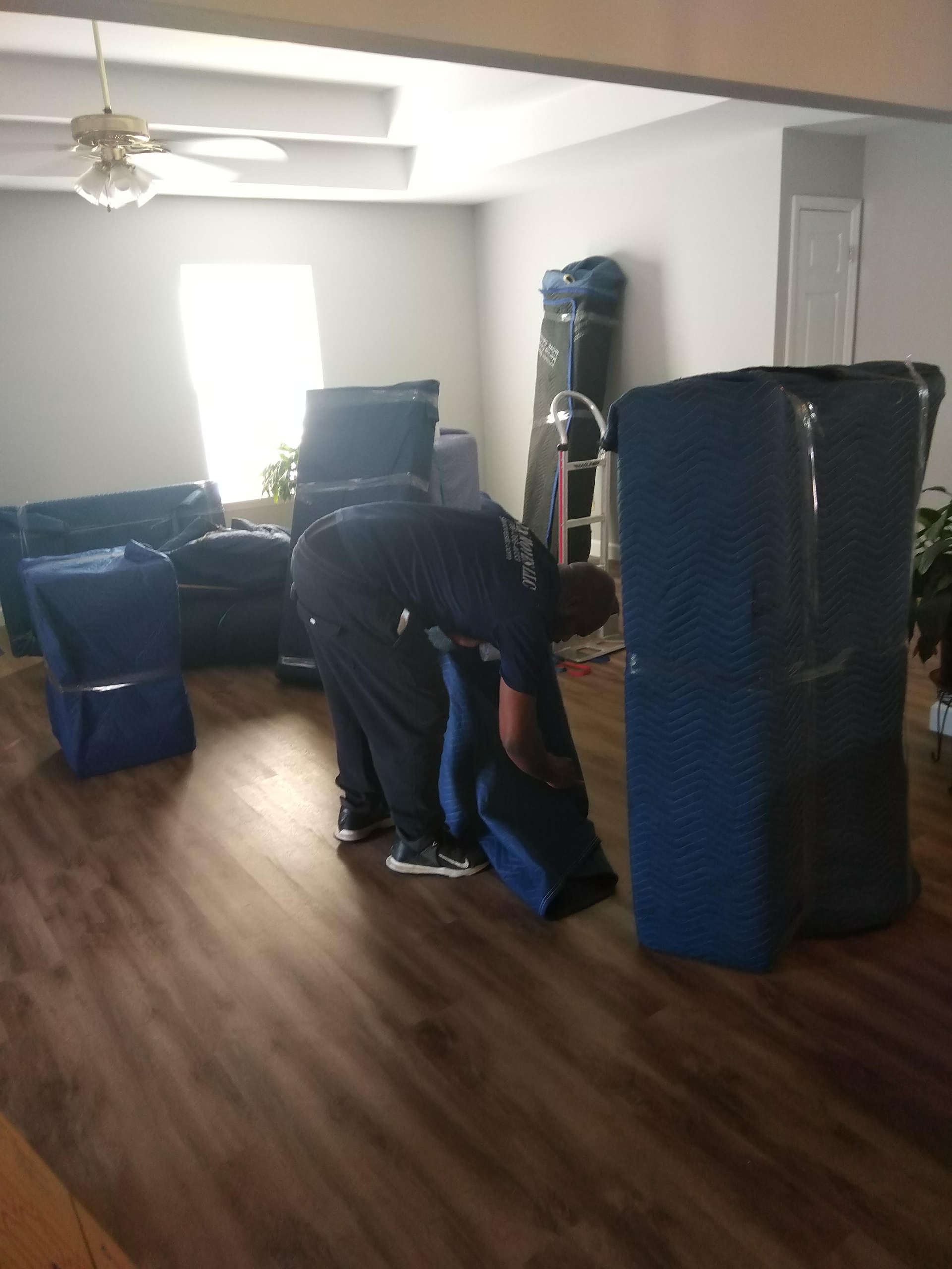 A man is moving a couch in a living room.
