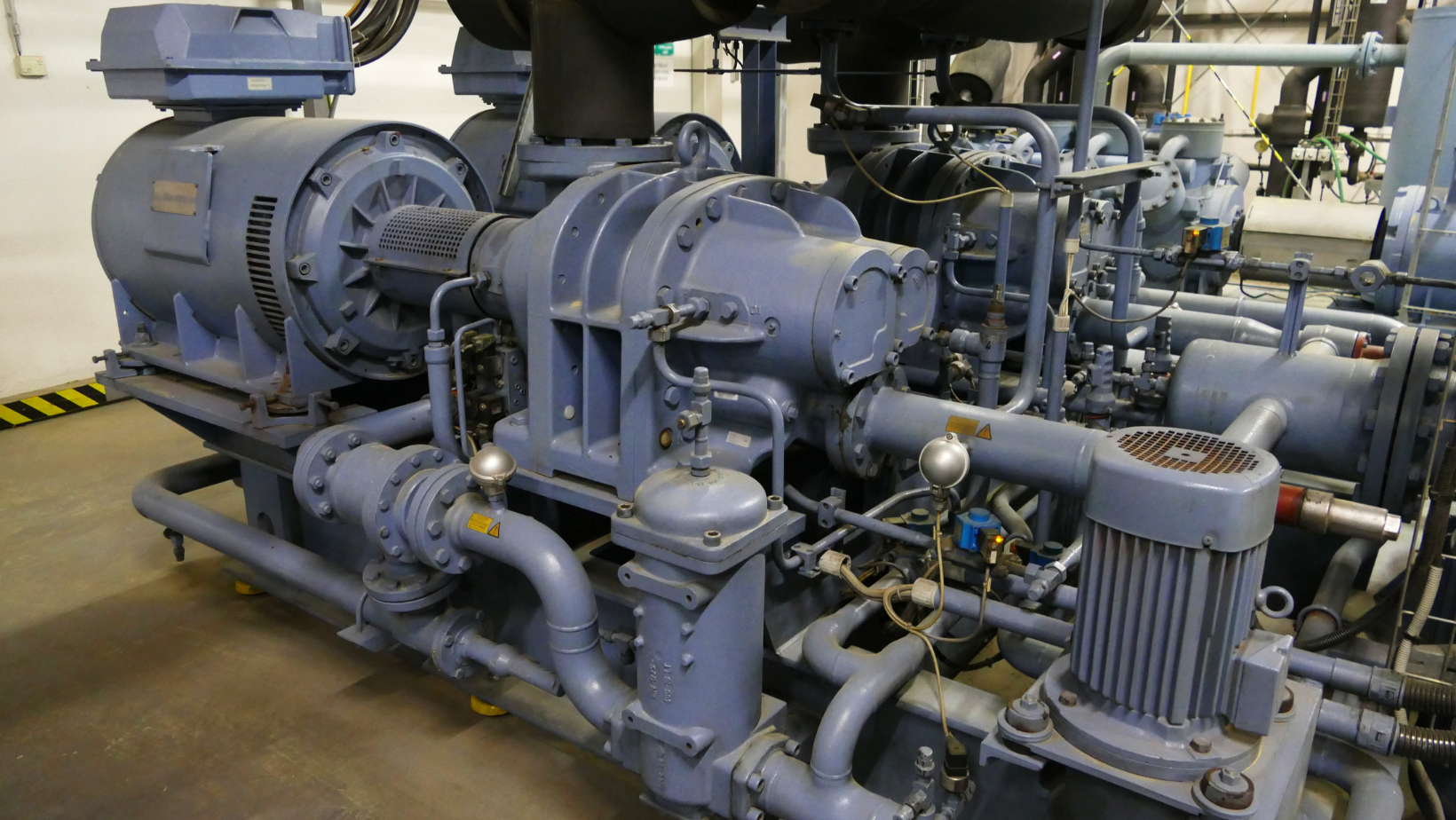 Industrial pump and motor machinery with gray pipes in a factory setting