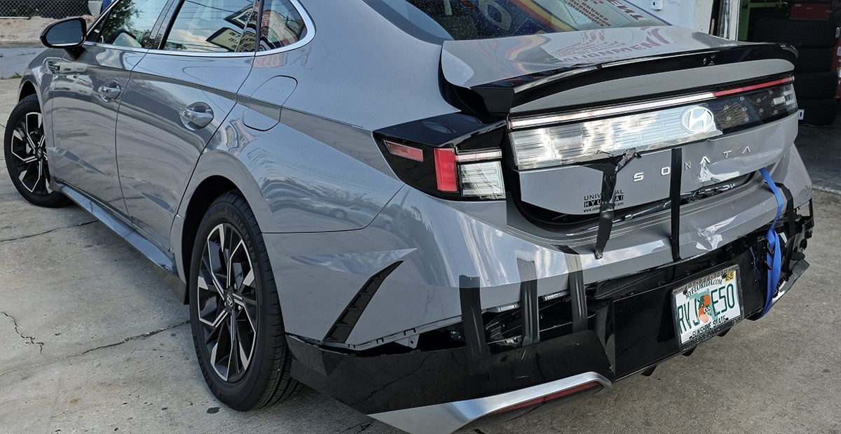 Gray sports sedan with black rear modifications parked in a driveway