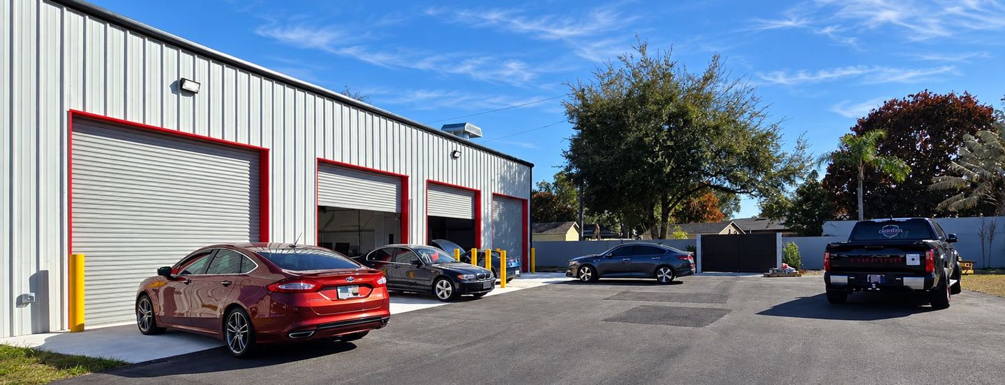 Industrial building with several parked cars on a sunny day
