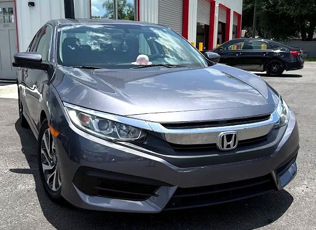 Silver Honda sedan parked outside a dealership