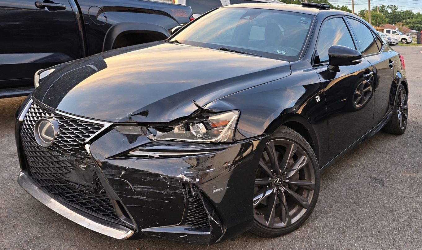 Black sedan with front-end damage parked in a lot