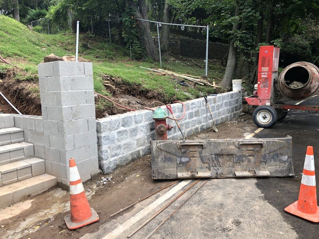 A concrete wall is being built next to a fire hydrant. A concrete wall is being built next to a fire hydrant.